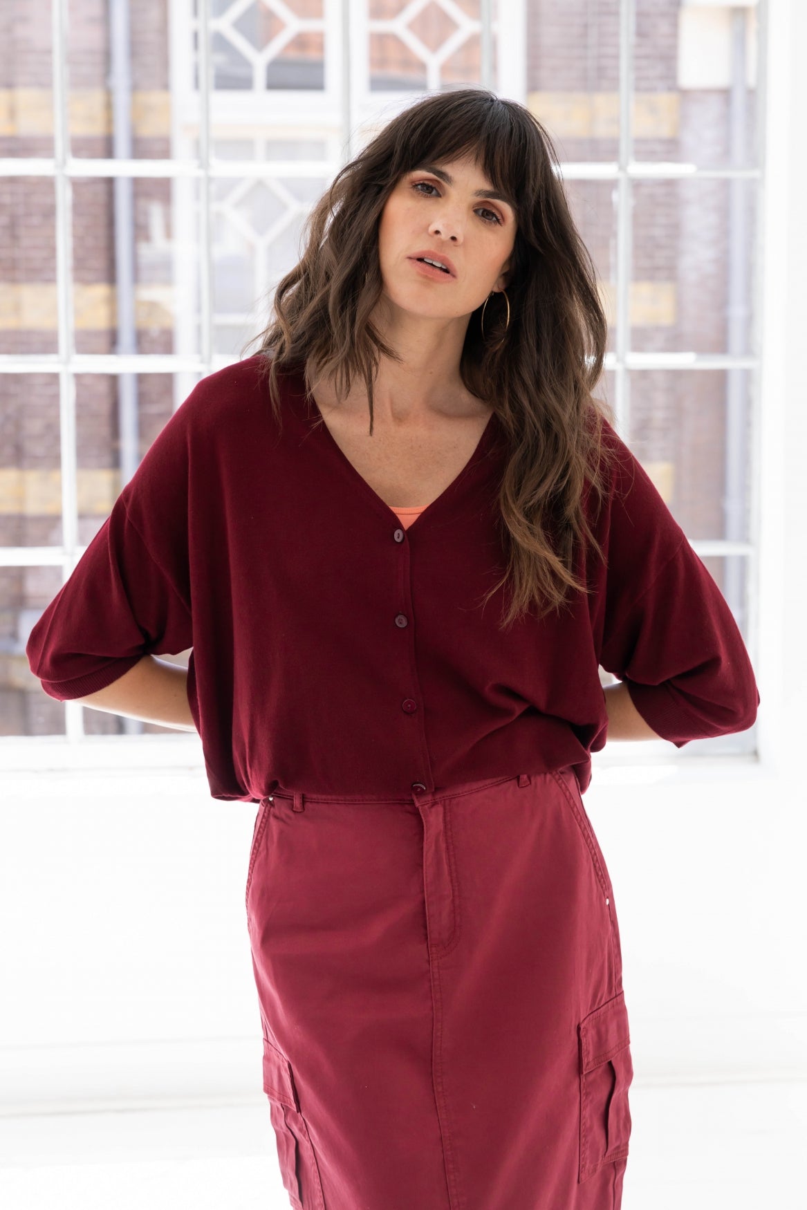 Woman wearing a wine coloured v neck cardigan knit