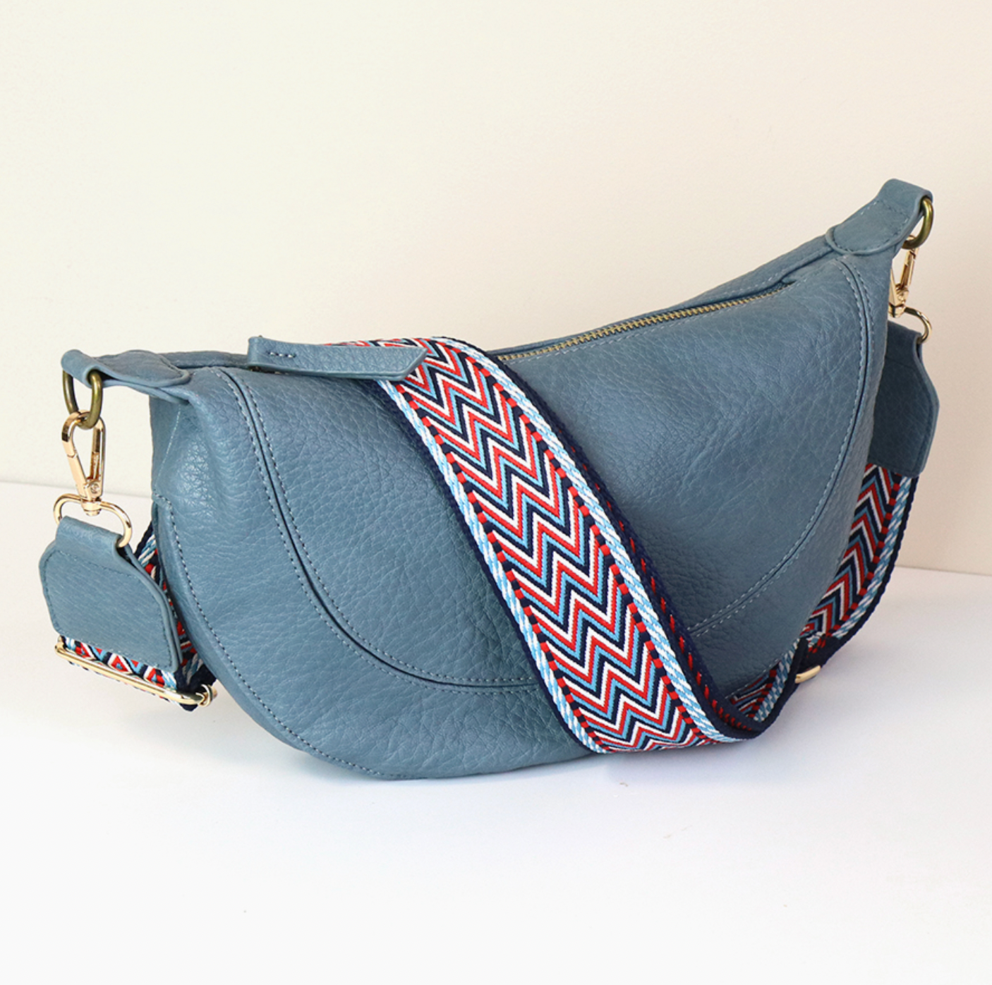 POM Vegan leather half moon handbag in denim blue with zig zag strap