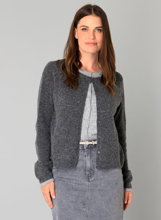 Woman wearing a faux layer grey cardigan with denim skirt