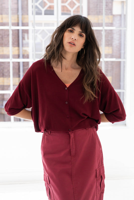 Woman wearing a wine coloured v neck cardigan knit
