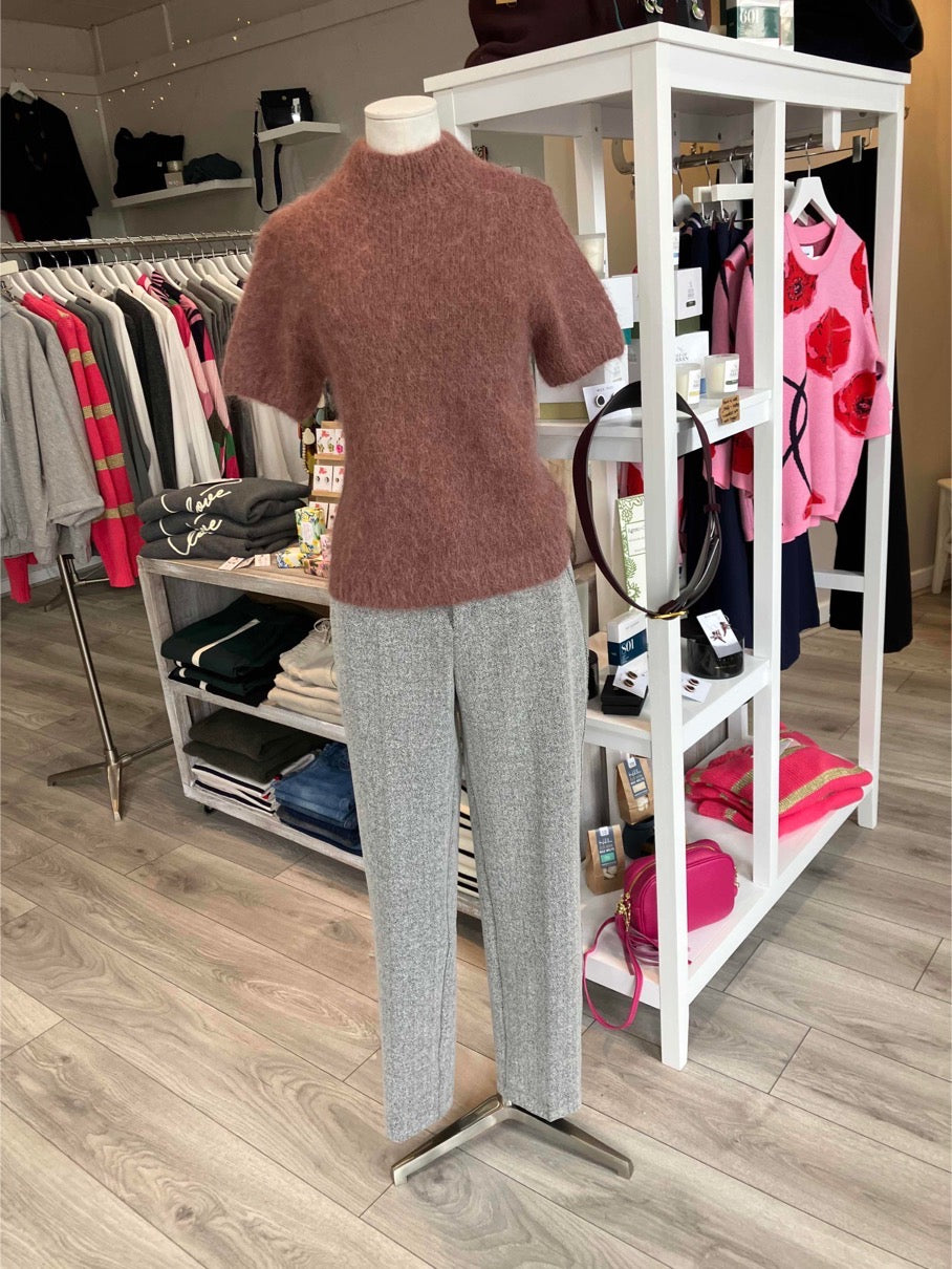 Mannequin wearing a dusky pink sweater and grey pants in a store setting 