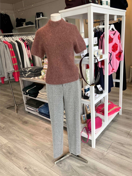 Mannequin wearing a dusky pink sweater and grey pants in a store setting 